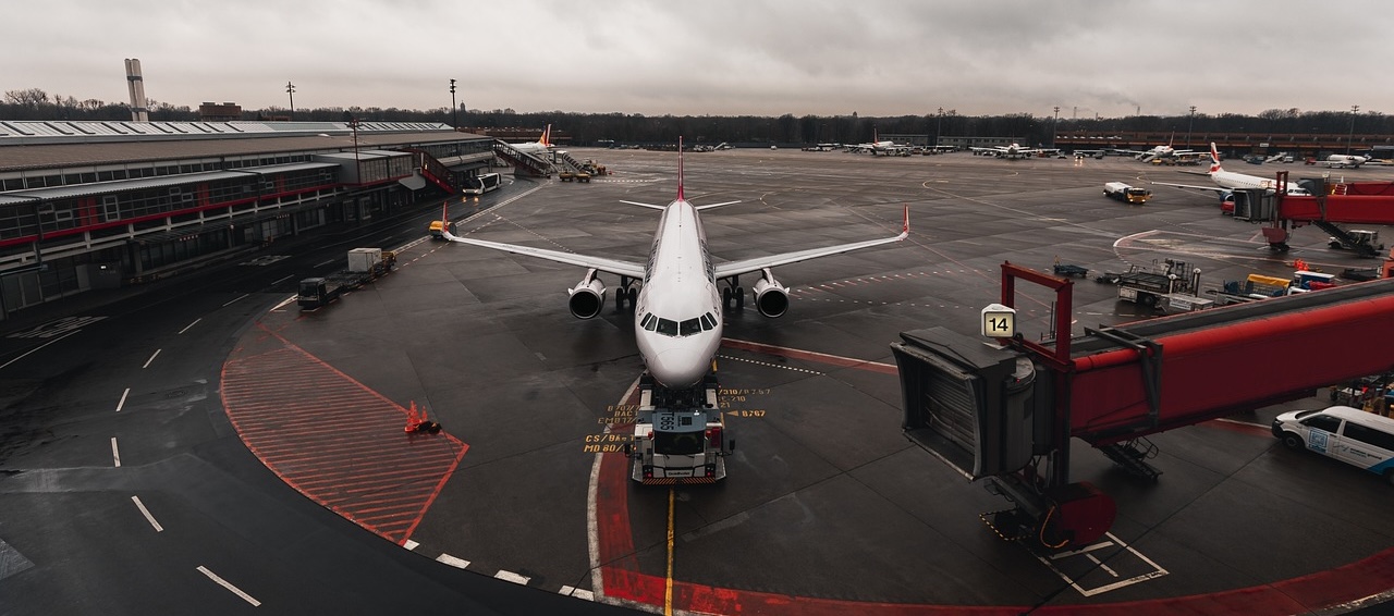 Commercial airliner parked at an airport gate beside a jet bridge
